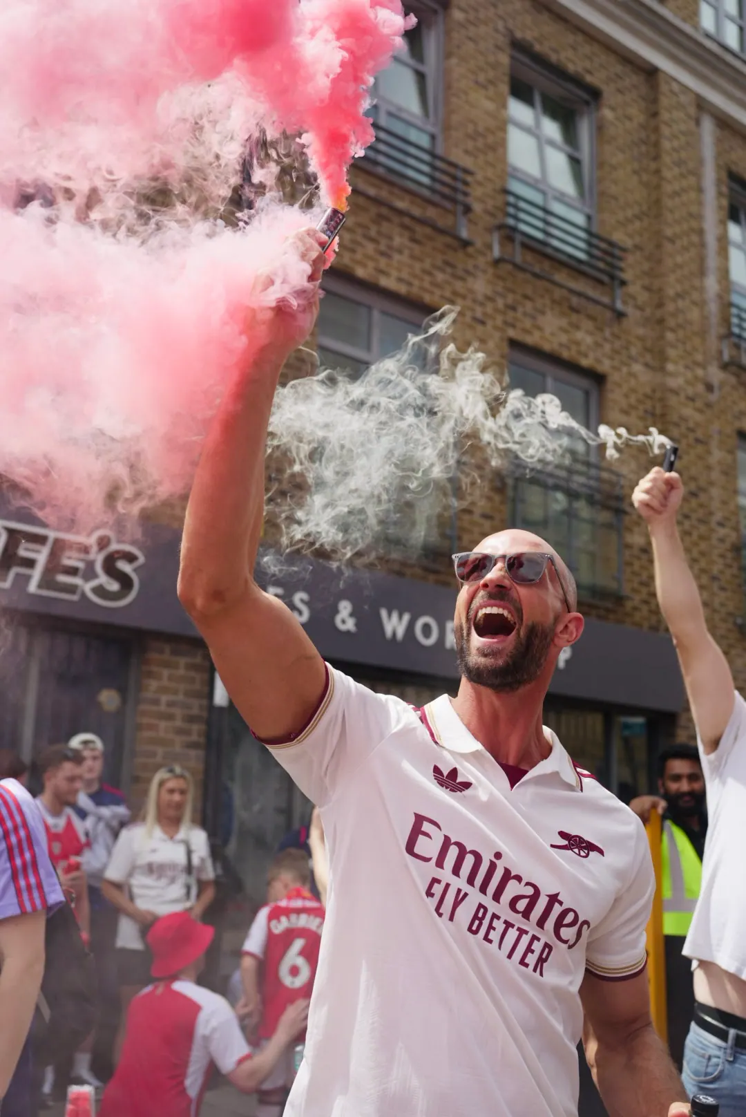 Daniel with a red smoke flare in an Arsenal shirt