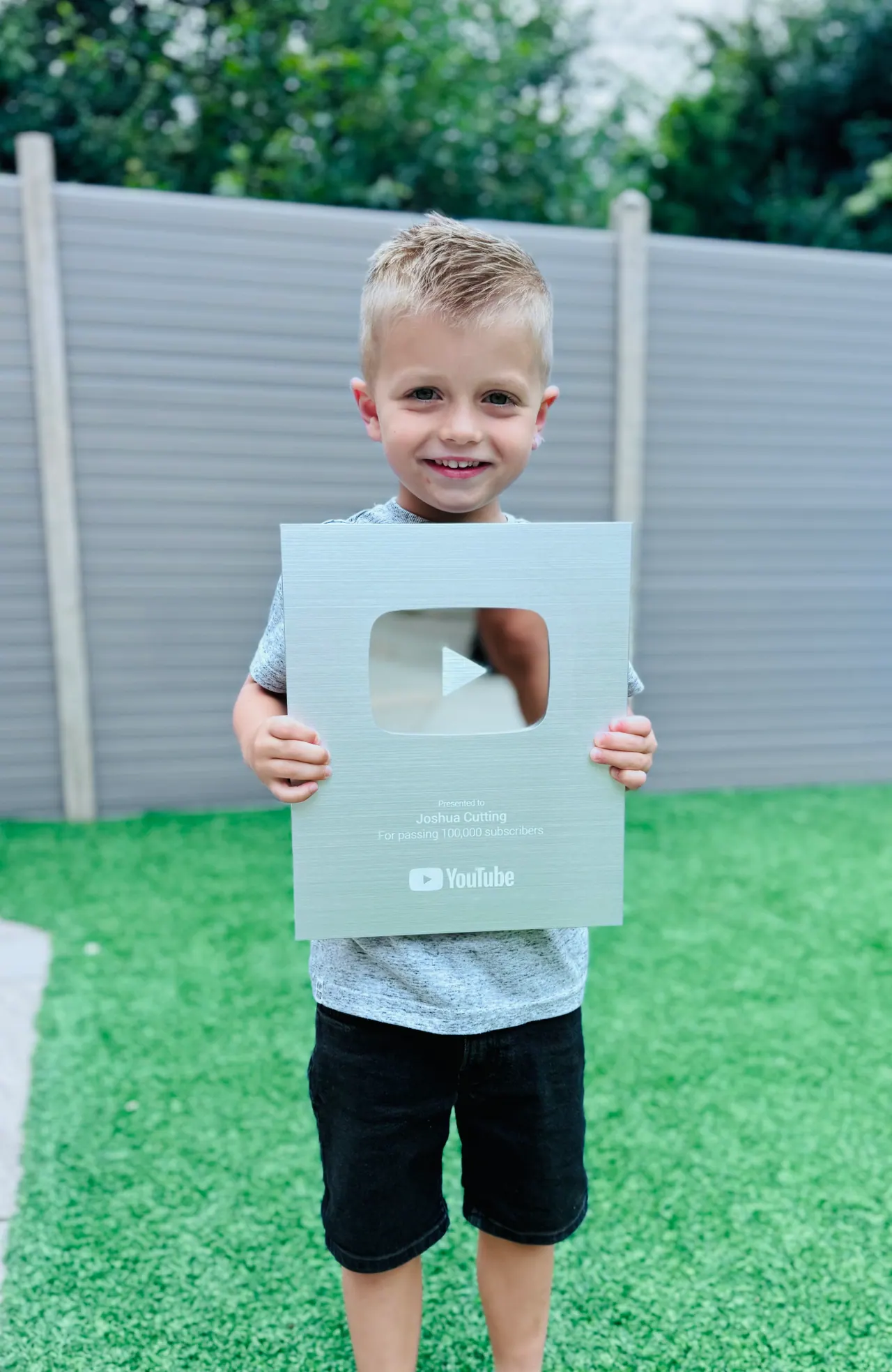 Joshua holding his YouTube Silver Play Button