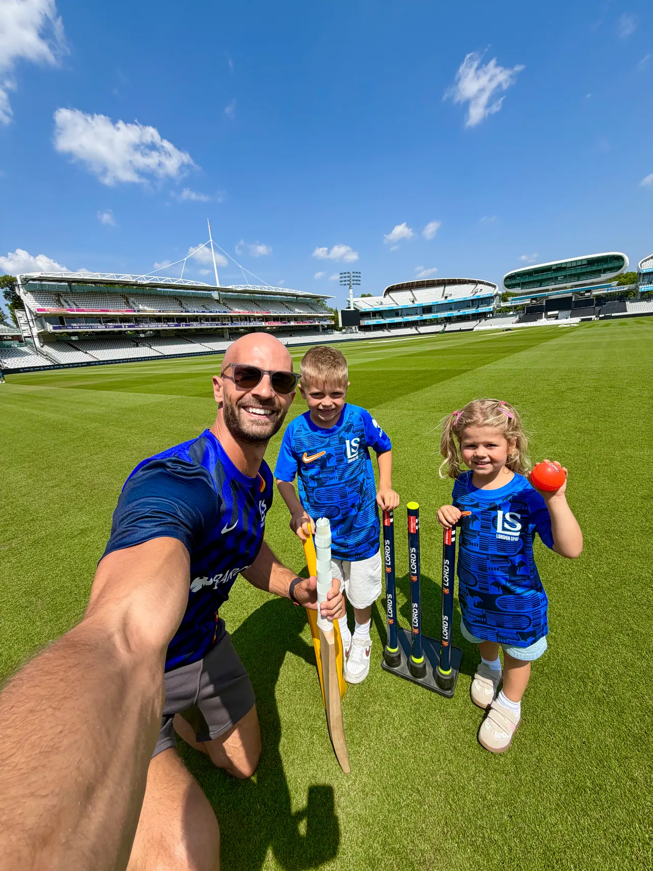 Daniel with Joshua and Sofia on the outfield at a cricket ground